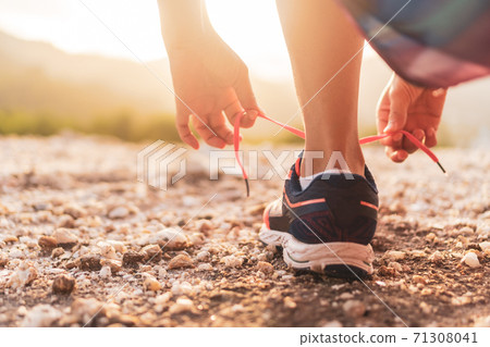 Woman wear running shoe on to walking and running on nature green background.Health exercise. Woman wear running shoe on to walking and running on nature green background.Health exercise. 71308041