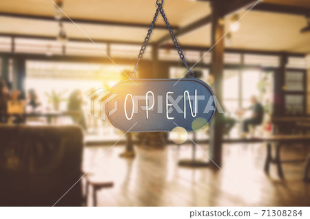 A business sign that says open on cafe or restaurant hang on door at entrance. A business sign that says open on cafe or restaurant hang on door at entrance. 71308284