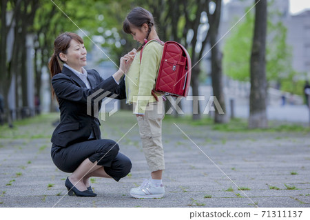 Mothers fixing children's clothing 71311137