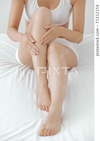 在床上按摩腿的婦女 在床上按摩腿的婦女 71312158