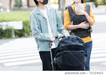 Image of a couple wearing a mask and pushing a stroller 71314421
