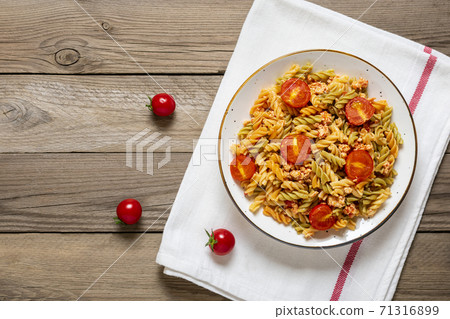 Fusilli - classic italian pasta from durum wheat with chicken meat, tomatoes cherry, basil in tomato sauce in white bowl on wooden table Mediterranean cuisine Top view Flat lay Fusilli - classic italian pasta from durum wheat with chicken meat, tomatoes cherry, basil in tomato sauce in white bowl on wooden table Mediterranean cuisine Top view Flat lay 71316899