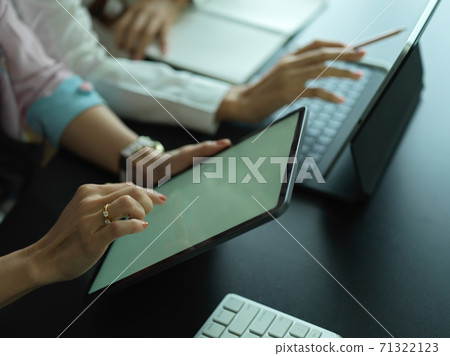 Close up view of two female workers working together on their project Close up view of two female workers working together on their project 71322123