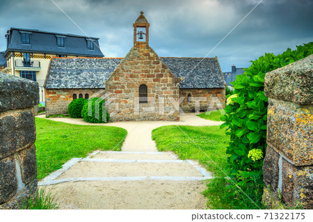 Old stone church with flowered entrance in Brittany region, France Old stone church with flowered entrance in Brittany region, France 71322175