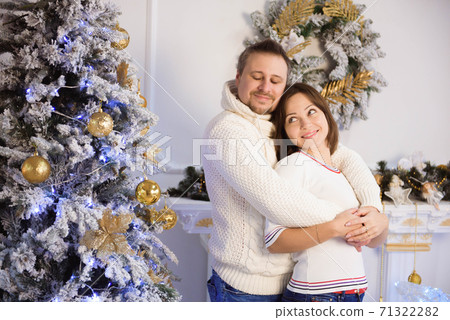 Young mother and father celebrating Christmas at home. Young mother and father celebrating Christmas at home. 71322282