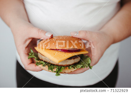 Overeating. Overweight woman with hamburger 71322929
