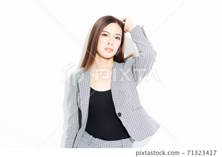 Business woman standing and posing in front of a white background 71323417