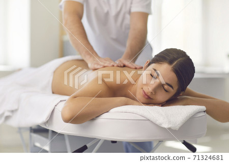 Young male osteopath doing professional back massage for woman in medical center. 71324681