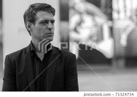 Young handsome businessman thinking in the city in black and white Young handsome businessman thinking in the city in black and white 71324734