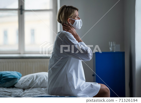 Woman patient sitting on bed in hospital feeling stressed, mental health and coronavirus concept. 71326194