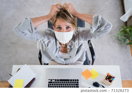 Top view of woman indoors in office feeling stressed, mental health and coronavirus concept. Top view of woman indoors in office feeling stressed, mental health and coronavirus concept. 71326273