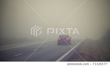 Bad weather driving - foggy hazy country road. Motorway - road traffic. Winter time. 71326577