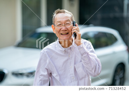 老人說在房子前面的智能手機 71328452