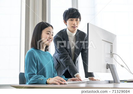 Casual business image Young men and women looking at the computer screen Casual business image Young men and women looking at the computer screen 71329084