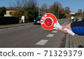 A little boy holds a stop sign at a pedestrian crossing 71329379