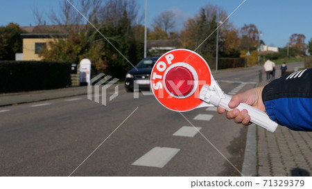 A little boy holds a stop sign at a pedestrian crossing A little boy holds a stop sign at a pedestrian crossing 71329379