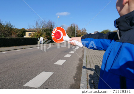 A little boy holds a stop sign at a pedestrian crossing A little boy holds a stop sign at a pedestrian crossing 71329381