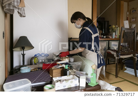 女工收拾一間凌亂的房間 71329717