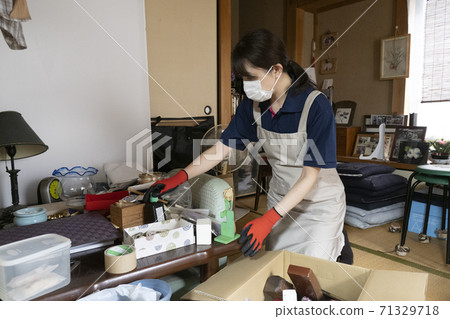 Female worker cleaning up a messy room 71329718