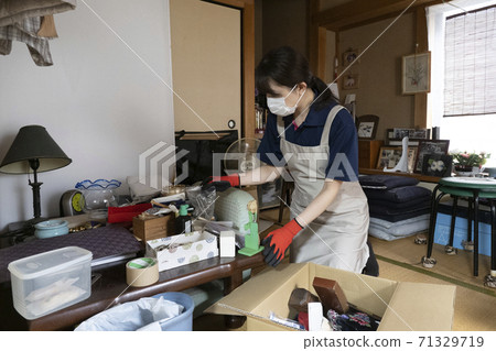 女工收拾一間凌亂的房間 71329719