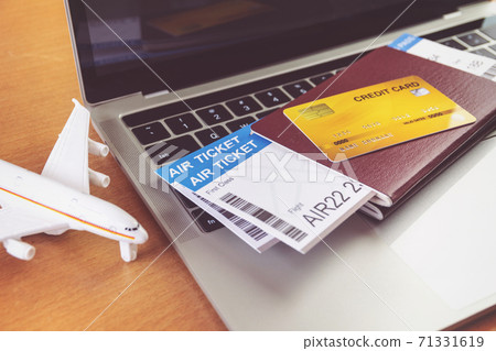 Air tickets and passports near laptop computer and airplane on table. Online ticket booking concept Air tickets and passports near laptop computer and airplane on table. Online ticket booking concept 71331619