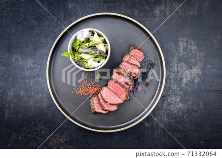 Modern style barbecue dry aged sliced fillet steak with spring salad and green and white asparagus  71332064