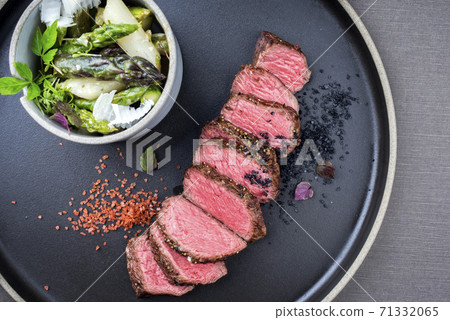 Modern style barbecue dry aged sliced fillet steak with spring salad and green and white asparagus  71332065