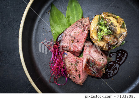 Traditional barbecue dry aged sliced venison filet steak with potato mushroom terrine Traditional barbecue dry aged sliced venison filet steak with potato mushroom terrine 71332083