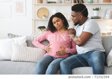 Black pregnant woman suffering from labor pains at home 71332384