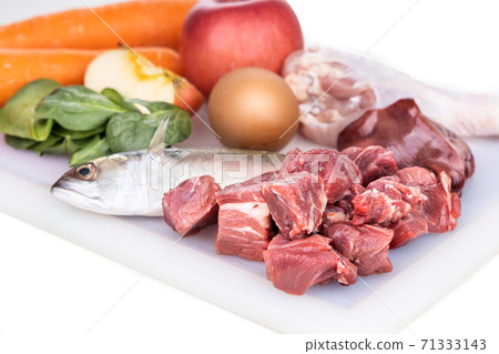 Closeup of ingredients of barf raw food recipe for dogs consisting meat, organs, fish, eggs and vegetable on chopping board Closeup of ingredients of barf raw food recipe for dogs consisting meat, organs, fish, eggs and vegetable on chopping board 71333143