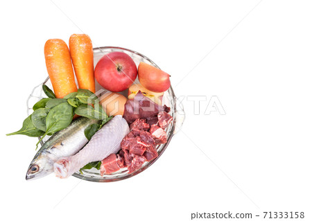 Overhead view on ingredients of barf raw food recipe for dogs consisting meat, organs, fish, eggs and vegetable in white background 71333158
