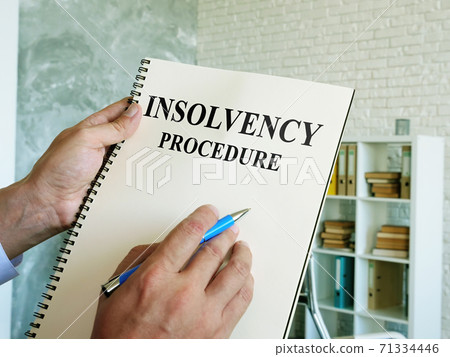 The man reads the insolvency procedure in the book. The man reads the insolvency procedure in the book. 71334446
