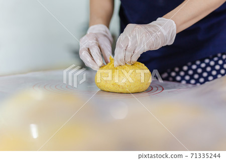Woman hands preparing bread dough on kitchen table. 71335244
