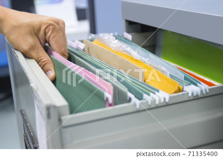 Hand of Man Search files document in a file cabinet in work office, concept business office life. 71335400