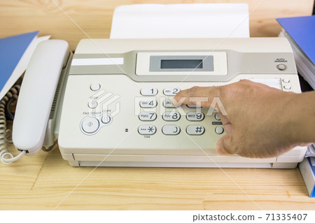 hand man are using a fax machine in the office, equipment for data transmission. 71335407