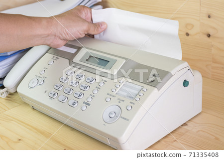 hand man are using a fax machine in the office, equipment for data transmission. hand man are using a fax machine in the office, equipment for data transmission. 71335408