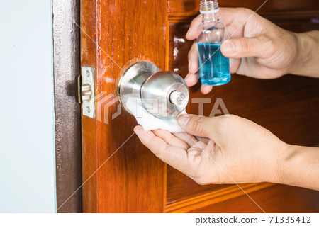 Prevention cleaning Door handles by Disinfectant solution for killing corona virus on touching surfaces, concept coronavirus COVID19 Prevention cleaning Door handles by Disinfectant solution for killing corona virus on touching surfaces, concept coronavirus COVID19 71335412