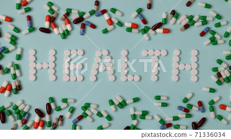 On table there is an inscription health around pills. On table there is an inscription health around pills. 71336034