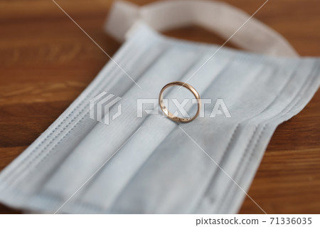 Wedding ring is on protective medical mask. Wedding ring is on protective medical mask. 71336035
