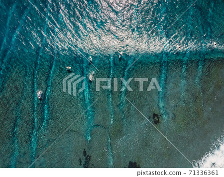 Aerial view of a surfers in blue ocean with waves. Top view 71336361