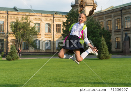 small girl jump with backpack. happy to be here. happy childhood memories. end of lesson 71336997