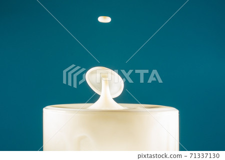 Two drops of milk fall into the long drink glass hitting each other then the liquid surface is shaped like a mushroom Two drops of milk fall into the long drink glass hitting each other then the liquid surface is shaped like a mushroom 71337130