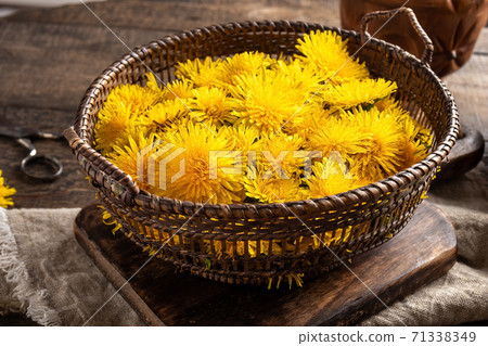 Dandelion blossoms in a wicker basket 71338349