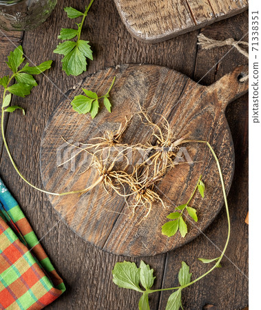 Fresh valerian roots and leaves on a table Fresh valerian roots and leaves on a table 71338351