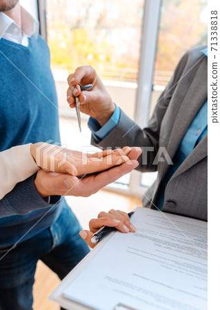 Realtor woman giving house keys to couple, closeup Realtor woman giving house keys to couple, closeup 71338818