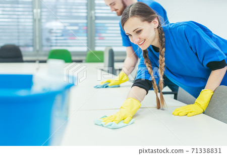 Cleaning crew wiping desks 71338831