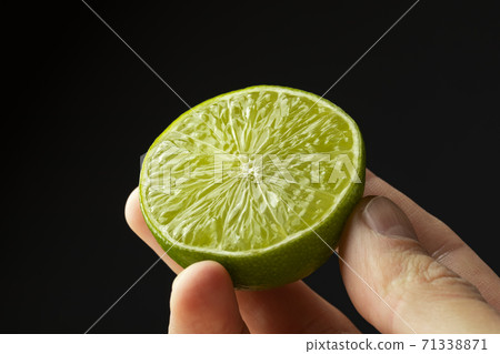 Half lime in the hand of a man. Half lime in the hand of a man. 71338871
