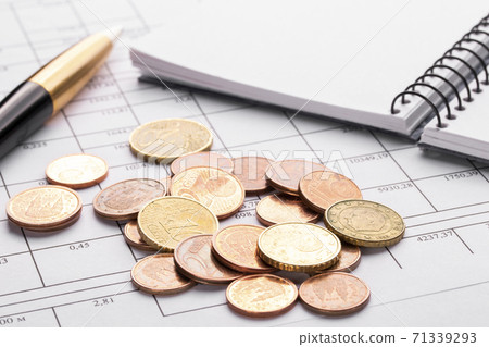 Stack of euro euro coins on old black wooden table. Pen, notebook and accounting documents. Concept of planning home expenses and paying bills 71339293