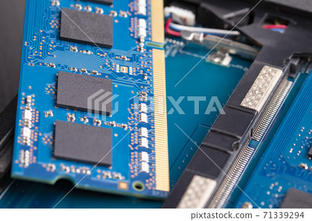 The blue card of the RAM for the laptop is prepared for installation in the slot, lies on the computer The blue card of the RAM for the laptop is prepared for installation in the slot, lies on the computer 71339294