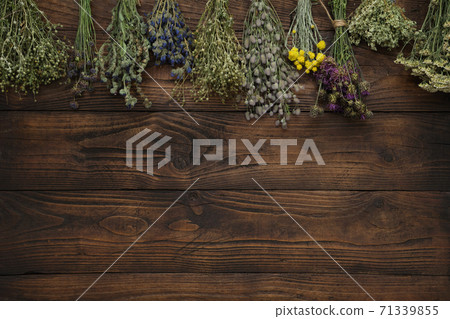 Medicinal plants bunches on brown wooden board. Top view, flat lay. Alternative medicine. Medicinal plants bunches on brown wooden board. Top view, flat lay. Alternative medicine. 71339855